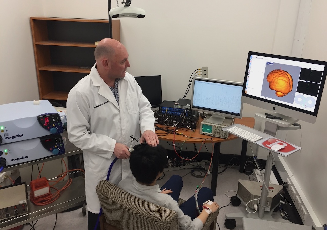 John Semmler applying non-invasive brain stimulation to a research participant